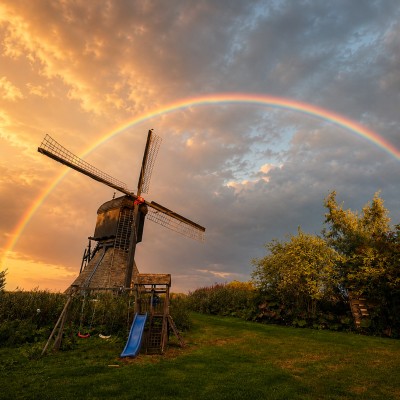 Volle regenboog over de Noordeloze molen op een zomeravond