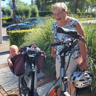 Oma met achterkleinkind in de fietstas