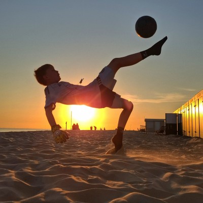 Voetbal in de laatste goude stralen van de ondergaande zon.